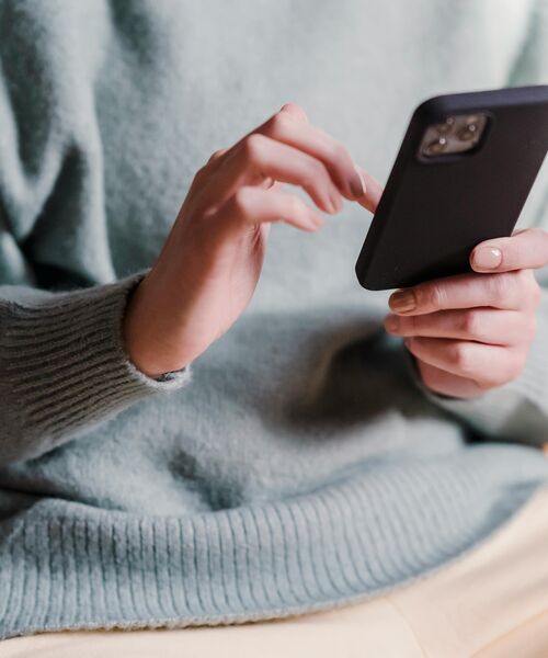 Nahaufnahme einer Person, die auf ihrem Smartphone tippt.