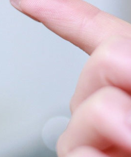 Nahaufnahme eines Fingers, der auf eine Glasoberfläche zeigt oder sie berührt.