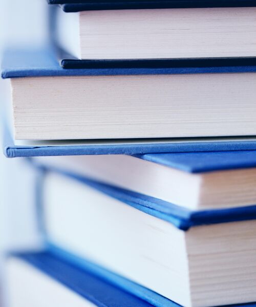 Nahaufnahme eines Stapels Bücher mit blauen Einbänden.
