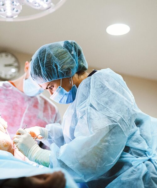 Ärzteteam in OP-Kleidung führt konzentriert eine Operation im Operationssaal durch.